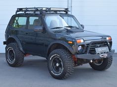 an off road vehicle parked in front of a garage