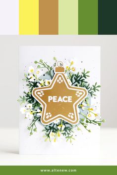 a christmas ornament on top of a card with flowers and greenery around it