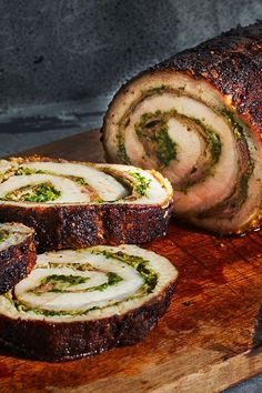 sliced meatloaf with pesto and cheese on wooden cutting board