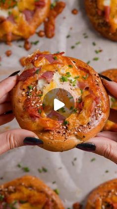 a person holding up a pizza doughnut with bacon and cheese on it's crust