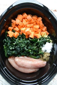 the food in the slow cooker is mixed with carrots, kale and other vegetables