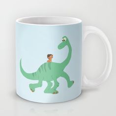 a green dinosaur mug with a boy on it