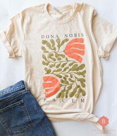 Express your faith, hope, and desire for peace with this unique "Dona Nobis Pacem" shirt. The phrase translates to "Grant us Peace" and is part of the Agnus Dei. Perfect for daily wear, this shirt combines a powerful Catholic message with stylish comfort. Made from 100% soft, breathable cotton, ensuring it's gentle on your skin and perfect for all-day wear. .: 100% combed and ring-spun cotton  .: Pre-shrunk fabric .: Blank product sourced from Nicaragua, Mexico, Honduras, or the US Production ta Catholic Shirt, Agnus Dei, Christian Shirt, Christian Shirts, Unisex Shorts, Shirt Price, Daily Wear, Favorite Outfit, Short Sleeve Tee