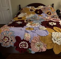 a crocheted bedspread with flowers on it in a bed room next to a door