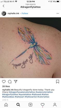 a dragonfly tattoo on the back of a woman's shoulder