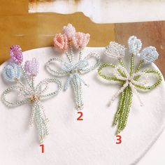 three bows are shown on top of a white plate with beading and beads in different colors