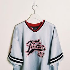 Vintage y2k silver / white / black Fubu jersey. FUBU 05 Jersey. FUBU 05 graphic logo on chest and back. embroidered badges on sleeve and chest. FUBU ATHLETICS 1992  Fubu jersey Fubu top Fubu shirt Fubu t shirt P2P 28 INCH, LENGTH 34 INCH Size XXL Good condition  UK AND WORLDWIDE SHIPPING SERVICE  FULLY TRACKABLE SHIPPING SERVICE Sporty Black Tops With Logo Patch, Black Sporty Top With Logo Patch, Sporty Black Top With Logo Patch, Jersey Tops With Team Logo For Streetwear, White Team Logo Top For Streetwear, White Streetwear Top With Team Logo, White Top With Team Logo For Streetwear, Collegiate Jersey For Streetwear During Sports Season, Throwback College Tops With Embroidered Logo