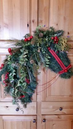 a christmas wreath hanging on the side of a wooden door