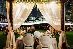 a bride and groom kissing at their wedding reception in the middle of an outdoor gazebo