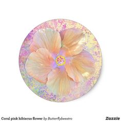 a white and pink flower on top of a glass plate with pastel paint splattered around it