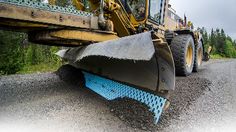 a bulldozer is parked on the side of the road with its front end up