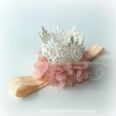 a white tiara with pink flowers on it and a pair of wooden paddles