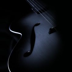 an acoustic guitar is shown in the dark with its strings still attached to it's neck