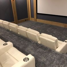 an empty theater room with white leather seats