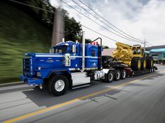 a large blue truck driving down a street