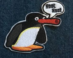 a black and white penguin with a speech bubble on it's head, sitting in front of a blue jean jacket