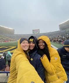 two women taking a selfie in the stands at a football game with snow on their faces