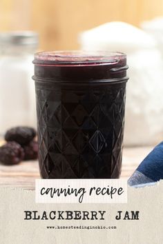 a jar filled with blackberries sitting on top of a table