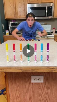 a man standing in front of a table with different colored tubes on it