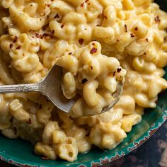 a green bowl filled with macaroni and cheese