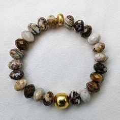 Ro & Gieo Wood Jasper and 24 karat Gold-plated Brass Bracelet Bead size - 10 - 11.5 mm Bracelet length - 7 inches If you want your bracelets in a different size than 7 inches, we are more than happy to accommodate your request. Please simply specify your WRIST SIZE IN INCHES into the ORDER SPECIAL INSTRUCTIONS section in cart checkout page. One size fit most - slightly elastic Slip-on style Perfect for everyday wear or dress up Wear alone or as a set or stacked with others Nature's beads with ra Gold Agate Crystal Bracelet Gift, Adjustable Gold Crystal Bracelet With Natural Stones, Gold Faceted Beaded Bracelets For Everyday, Gold Agate Bangle Bracelet, Gold Agate Bangle Jewelry, Gold Spiritual Stretch Bracelet With Faceted Beads, Gold Agate Bangle, Spiritual Gold Stretch Bracelet With Faceted Beads, Gold Bracelets With Natural Round Beads