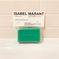 a green soap bar sitting on top of a bathroom sink next to a white tile wall