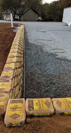 several bags of cement sitting on the side of a road