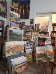 there are many paintings on the easel in this room and one is sitting down