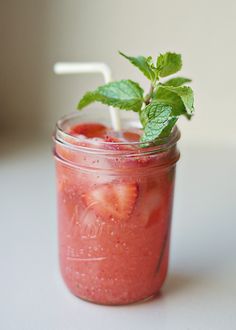 a mason jar with strawberries and mint garnish