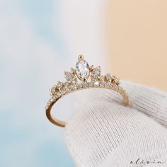 "Indulge in regal charm with our Crown-Shaped Vintage Ring, featuring a dazzling marquise-cut white sapphire embraced by genuine diamonds. This exquisite piece exudes timeless elegance and vintage allure, making it a captivating addition to your collection. F E A T U R E S 💎 D I A M O N D Carat: 0.30 Quality: VS1 Color: F-G Cut: Round 💠 G E M S T O N E Type: White Sapphire Carat: 0.25 Cut: Marquise 🌟 M A T E R I A L Gold: Available in 14K and 18K Options Color: Choices of White, Rose, or Yellow 🎁 Extra Touch: As a testament to our dedication to exceptional customer service, each purchase is accompanied by a complimentary product certificate. Your order will be elegantly presented in a stylish box within a chic pouch for that added touch of sophistication. ☆ ☆ ☆ F R E E S H I P P I N G Princess Engagement Rings Vintage, Tiara Promise Rings, Engagement Ring Crown, Crown Shaped Rings, Engagement Rings Gold Elegant, Cute Dainty Wedding Rings, Crown Engagement Rings, Lowkey Engagement Rings, Kawaii Engagement Ring