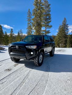 a black suv is parked in the snow