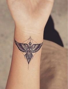 a small tattoo on the wrist of a woman's left arm, with an intricate design