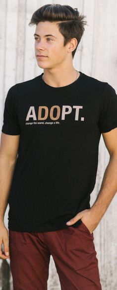 a young man wearing a black adopt t - shirt