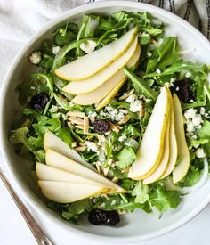 a salad with pears and feta cheese in a white bowl