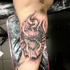 a man with a cross and heart tattoo on his leg