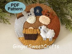 a felt ornament hanging from a christmas tree with sheep and lambs on it