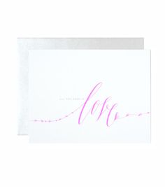 a card with the word love written in cursive pink ink on white paper