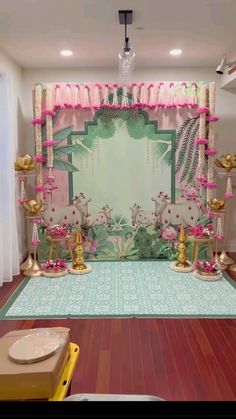 a stage set up for a party with pink and gold decorations on the floor,