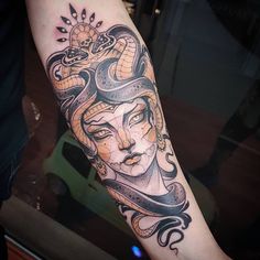 a woman's arm with a snake and sun tattoo design on the left forearm