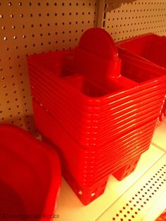 two red plastic containers sitting on top of a shelf