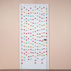 the door is decorated with multicolored polka dots and has a wooden floor in front of it