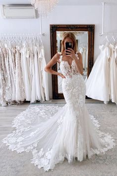 a woman is taking a selfie in front of her wedding gowns and dresses