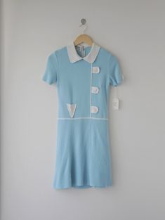 Très chic short-sleeve drop waist dress, from the 60s's Ye-Ye French pop style.  Peter Pan collar. The front and sleeves detail with cheerful decorative. Zipper on the back.  Colors: Azure blue, white  Size: 9 (Japan), fits like modern XS, S Fabrications: 60% acrylic, 40% rayon.  Maker: Renown Woman's young fashion Ye-Ye  Condition: excellent  Country of origin: Japan Retro Short Sleeve Day Dress, Retro Short Sleeve Dress For Daywear, Fitted Retro Mini Dress With Buttons, Retro Knee-length Mini Dress For Daywear, Knee-length Retro Mini Dress For Daywear, Retro Short Sleeve Dress With Buttons, Fitted Short Sleeve 1950s Dress, Blue Vintage Short Sleeve Mini Dress, Vintage Blue Short Sleeve Mini Dress