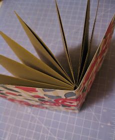 an open book sitting on top of a table next to a pair of scissors and paper