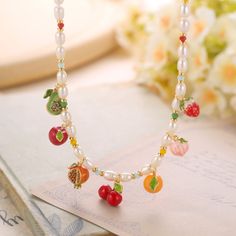 Elevate your accessory game with the Fruit Charm Necklace, a delightful piece that brings the vibrant essence of nature's bounty to your jewelry collection. This fruit necklace features an array of meticulously crafted fruit charms, each adorned with rich enamel detailing and plated in luxurious 18K gold. From sweet strawberries to luscious cherries, each charm captures the vivid colors and intricate details of the fruits, symbolizing abundance, joy, and prosperity. Details Plating: 18K Gold Mat Orange Jewelry With Fruit Design For Gifts, Orange Fruit Design Jewelry For Gift, Orange Fruit Design Jewelry Gift, Multicolor Pearl Charm Jewelry Gift, Multicolor Pearl Charm Jewelry As Gift, Multicolor Jewelry With Pearl Charm For Gift, Multicolor Jewelry With Pearl Charm As Gift, Whimsical Beaded Chain Necklace As Gift, Whimsical Colorful Beads Jewelry For Gifts