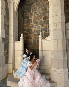 two women in dresses sitting on the steps