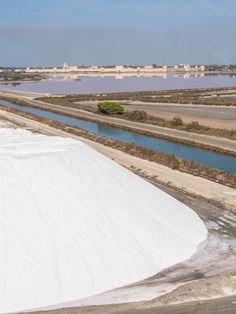 a large mound of snow sitting next to a river