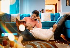 a man and woman are sitting on the floor with a book in their hands while they look at each other