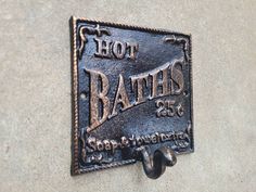 a metal sign that says hot baths on it