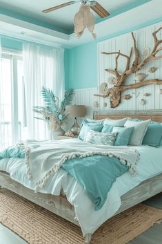 a bedroom with blue walls and white bedding in the center is decorated with driftwood pieces